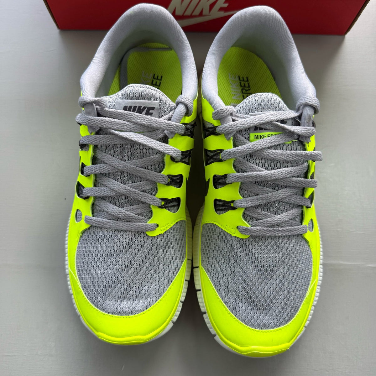 Nike grey trainers with black accents and distinctive Free 5.0 design.