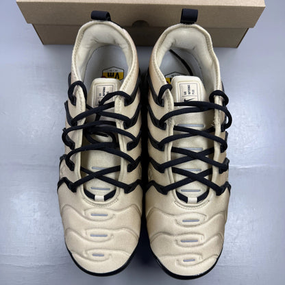 Nike beige trainers with black accents and Air cushioning design.