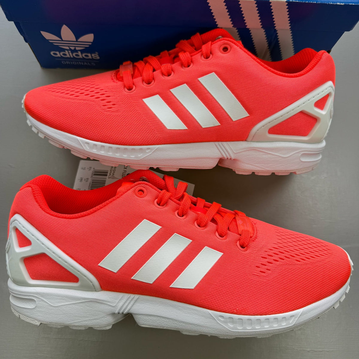 Adidas ZX Flux EM red trainers with white accents and textured mesh upper.
