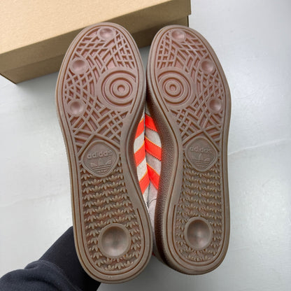 Adidas grey trainers with coral accents and gum sole, featuring classic logo.