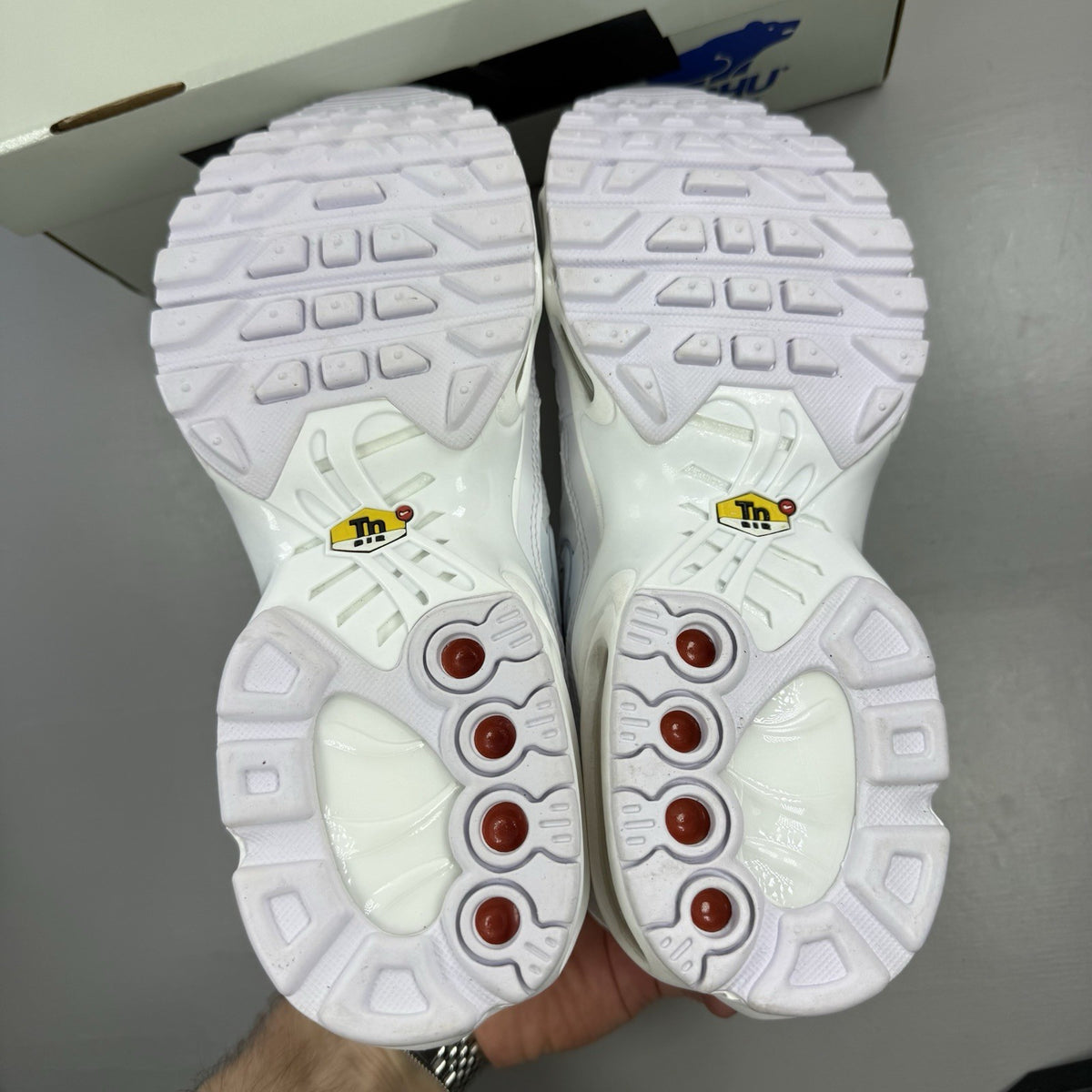 Nike Air Max Plus TN white trainers with metallic silver accents and grey detailing.