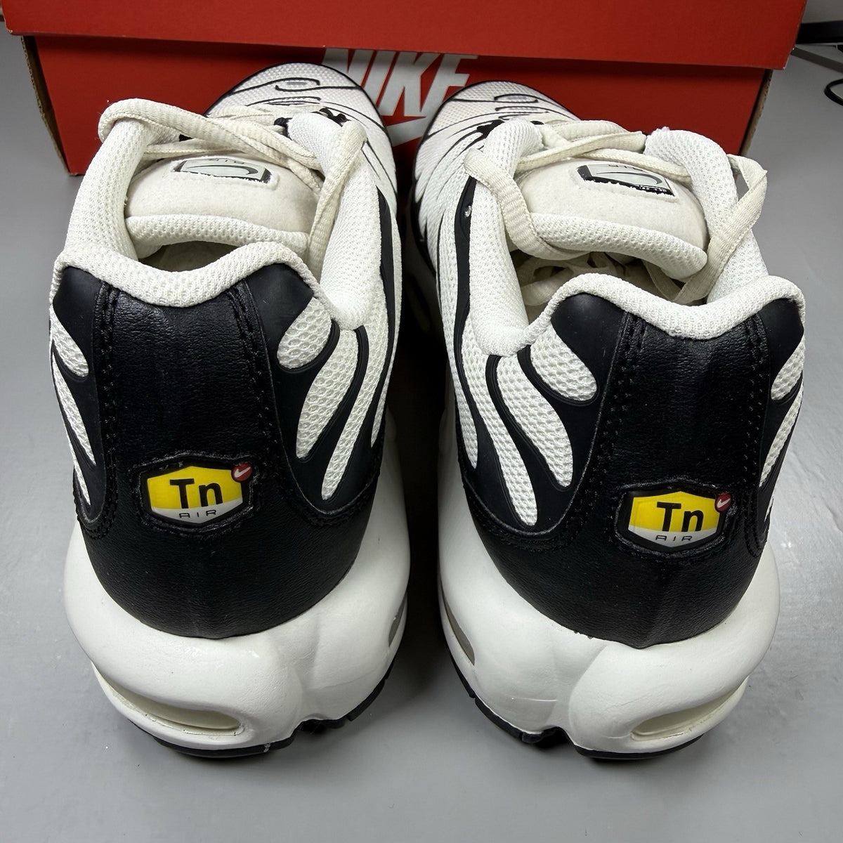 Nike Air Max Plus TN trainers white with black accents and signature logo details.