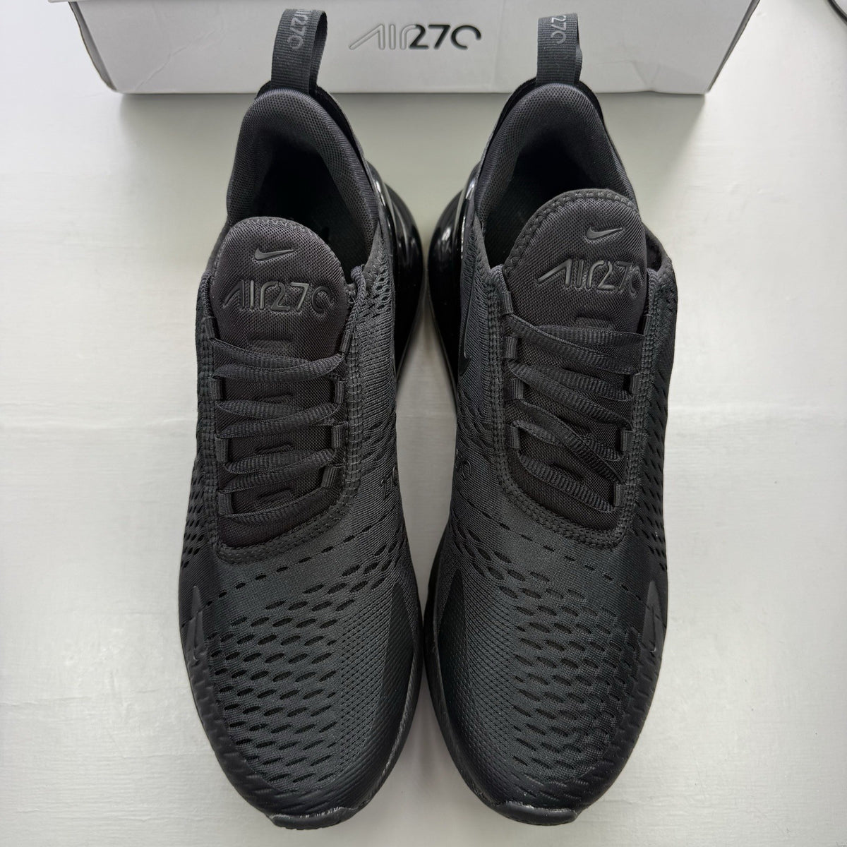 Nike Air Max 270 trainers black with logo detail and sleek design.