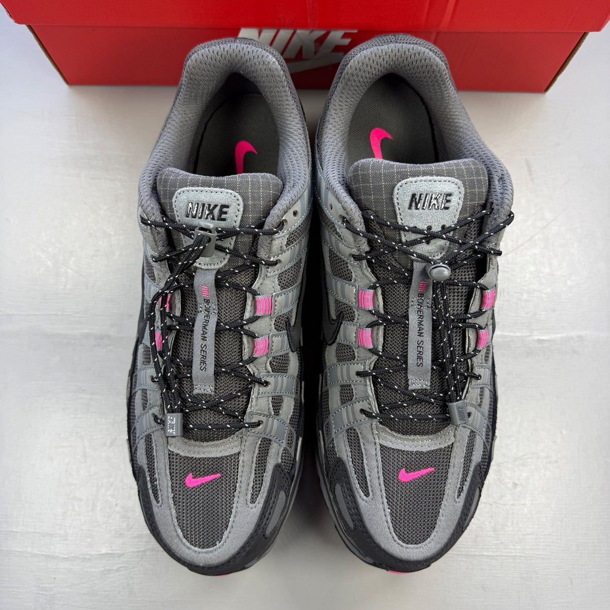 Nike P-6000 trainers grey with pink and black accents, mesh material, logo on tongue.