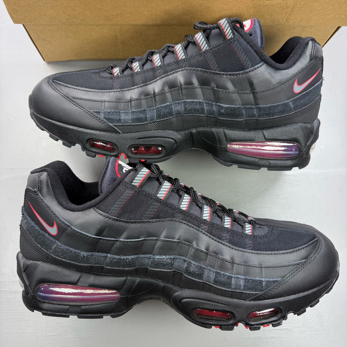 Nike Air Max 95 black trainers with red accents and signature big bubble sole.