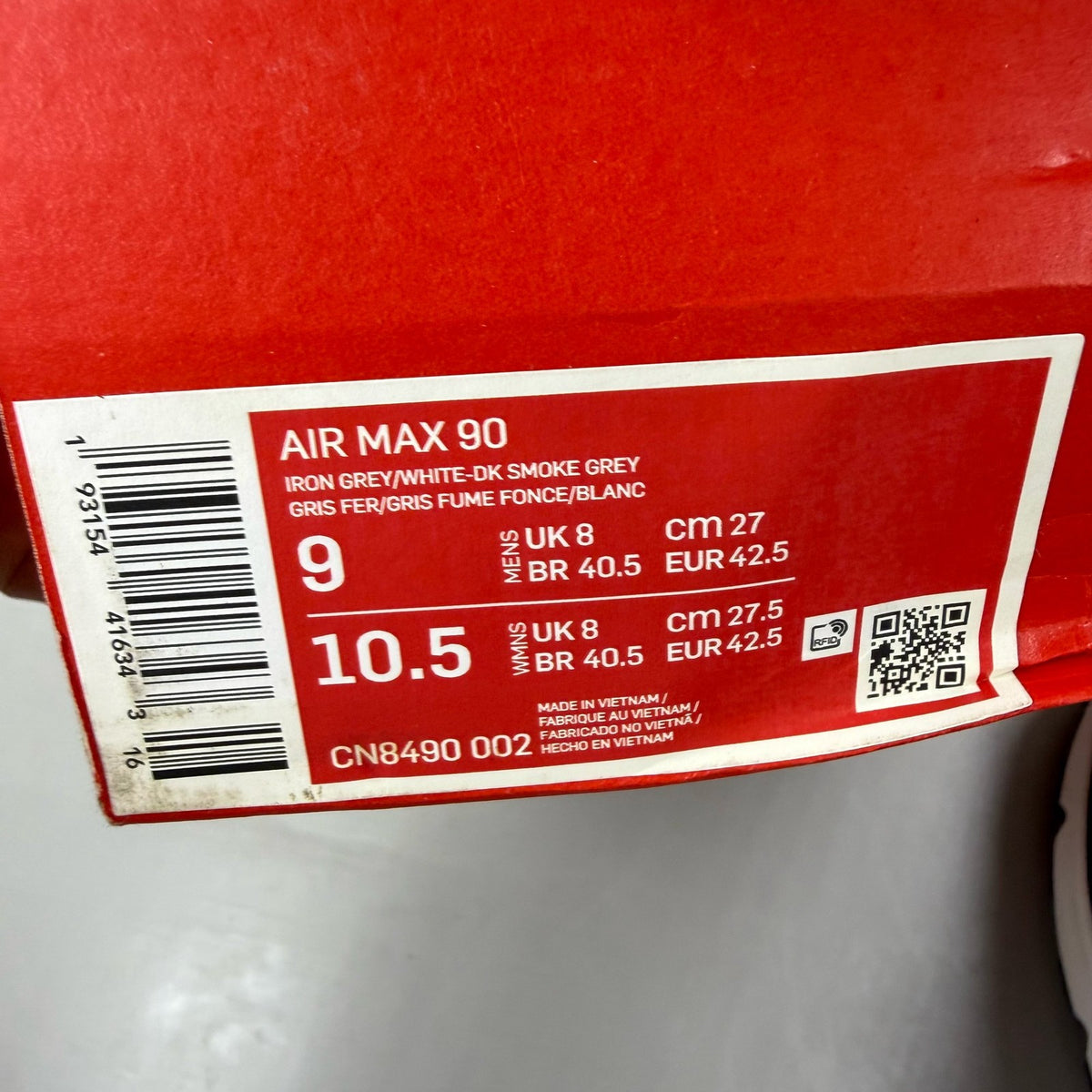 Nike Air Max 90 black trainers with grey accents and signature swoosh logo.