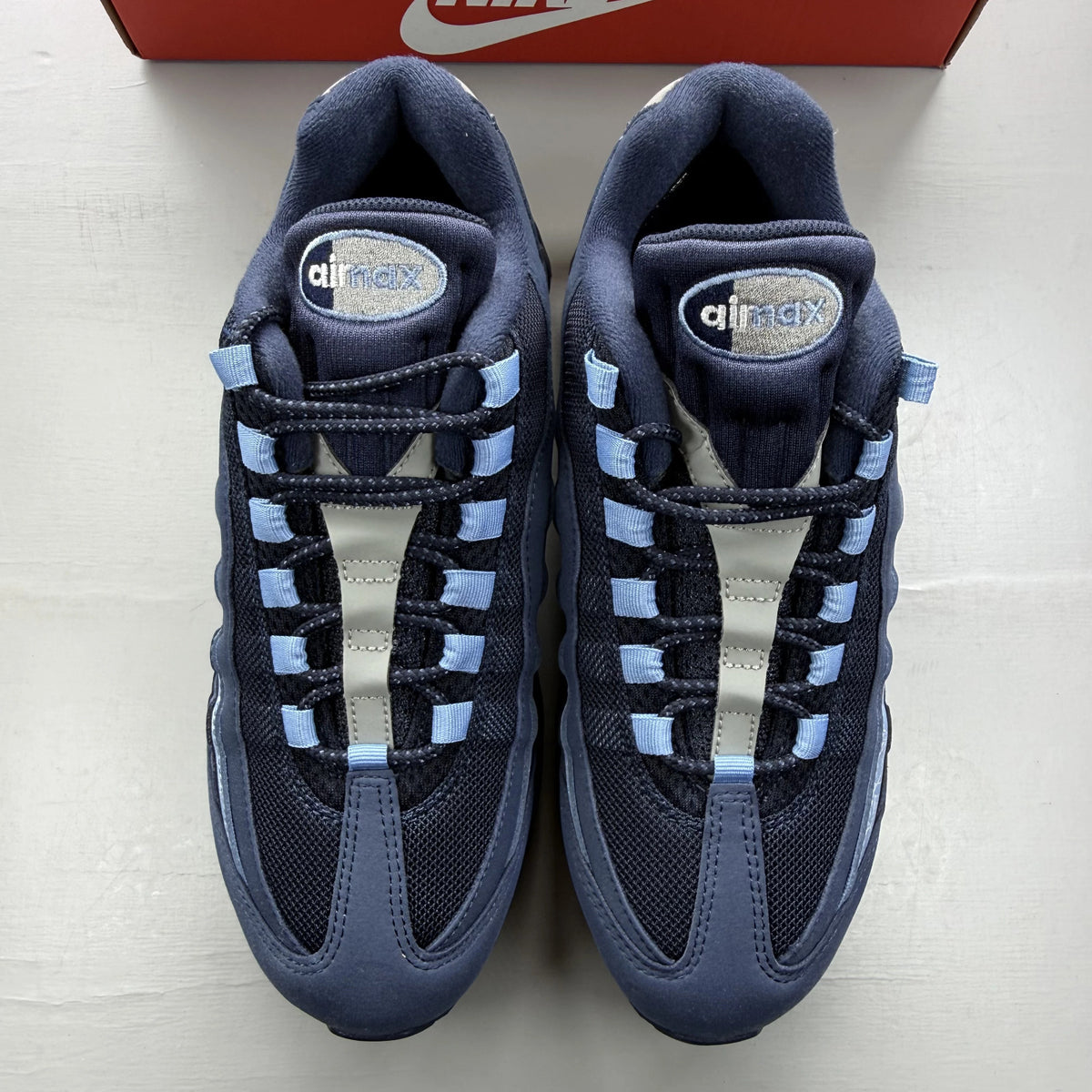 Nike Air Max 95 blue trainers with big bubble sole and branded logo details.