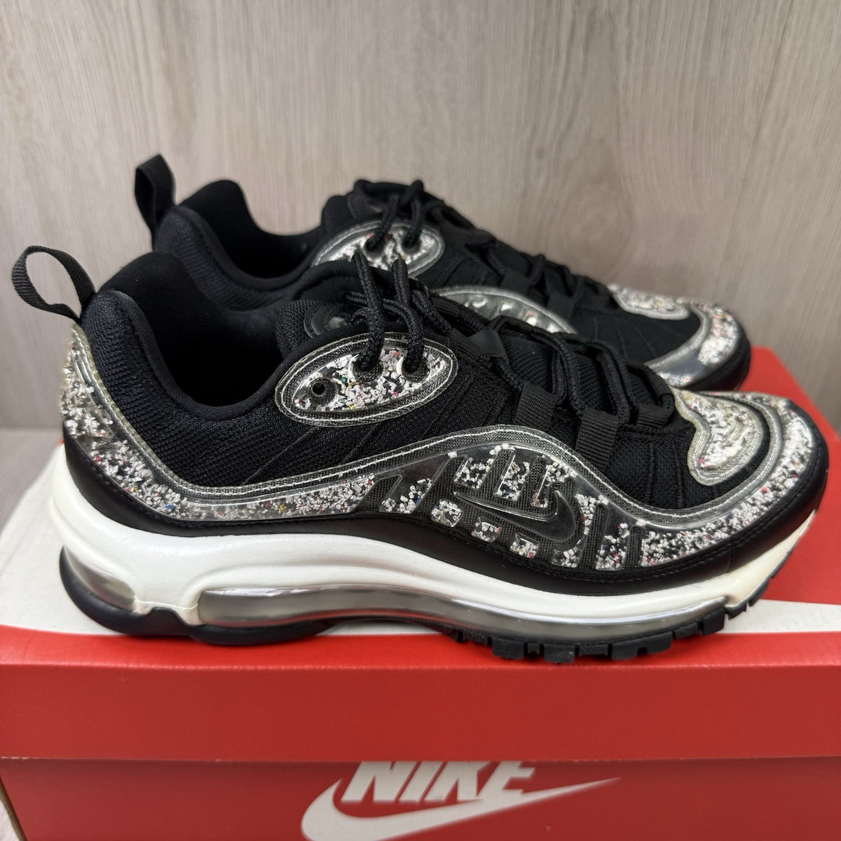 Nike Air Max 98 trainers black with white accents and signature logo detail.