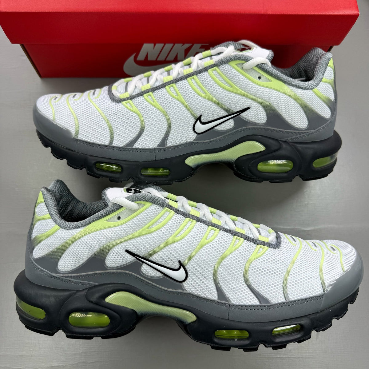 Nike trainers white with cool grey and liquid lime accents, featuring iconic swoosh logo.