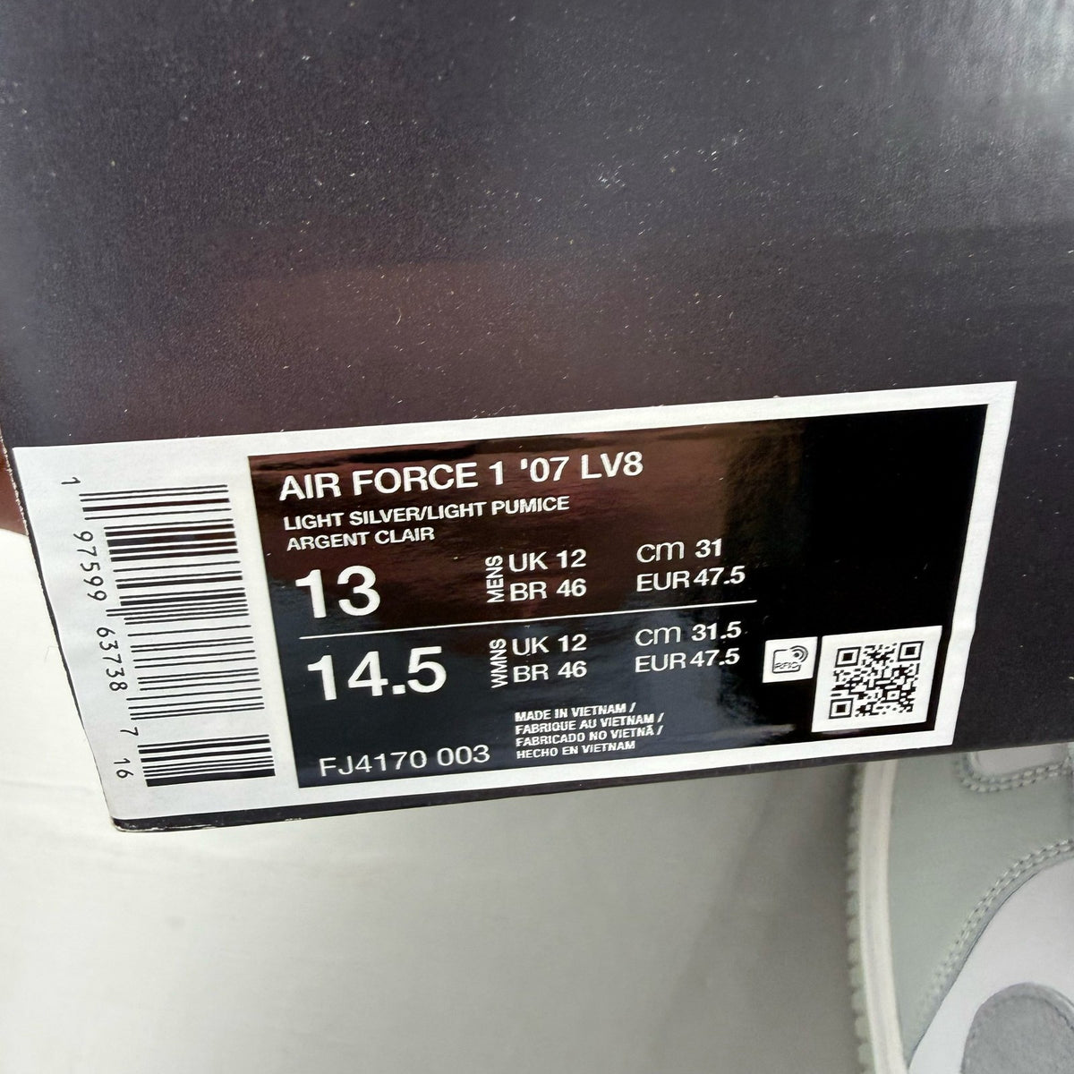 Nike Air Force 1 grey low-top sneakers with light silver accents and white sole.