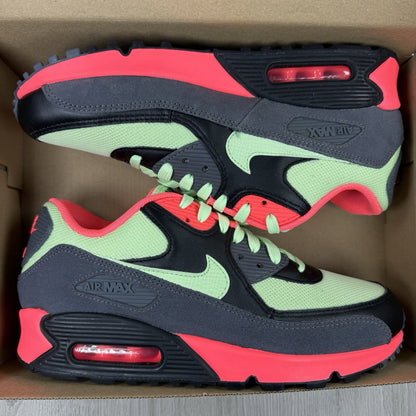 Nike Air Max 90 Essential green trainers with signature swoosh logo and mesh detailing.