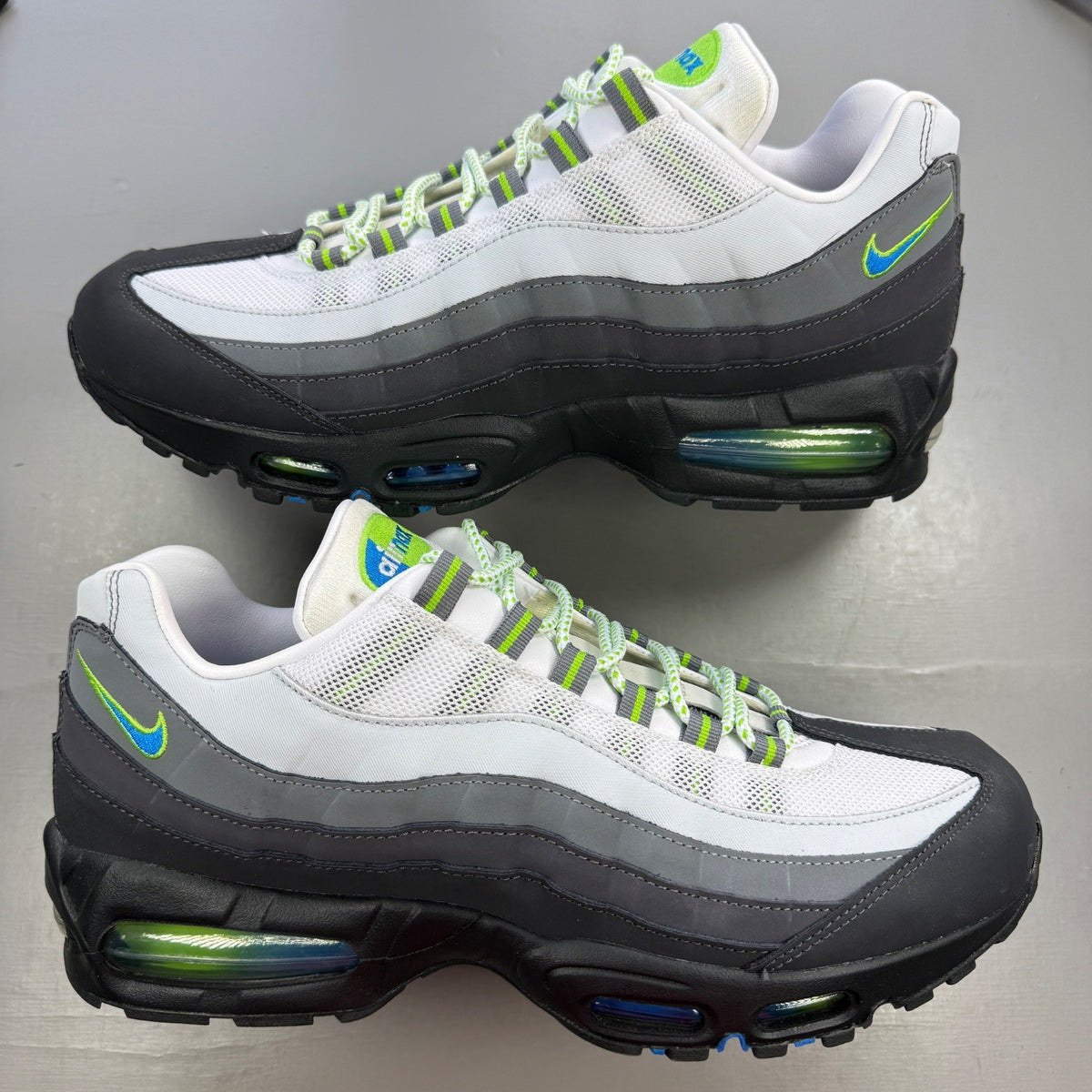 Nike Air Max 95 green trainers with big bubble design and blue accents.