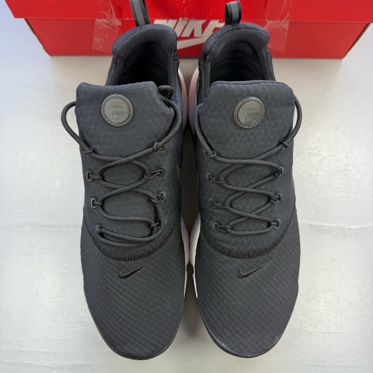Nike black trainers with white accents and sleek design, featuring logo details.