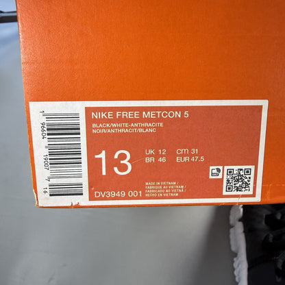 Nike black trainers with white and anthracite accents, featuring a sleek design and logo.