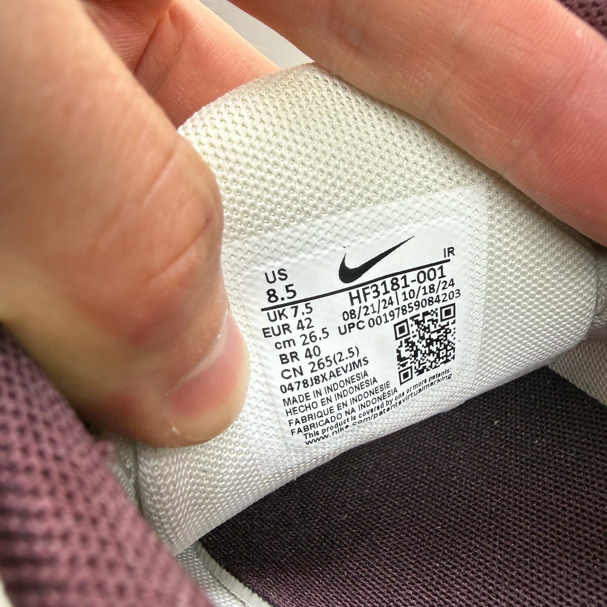 Nike Air Max Plus TN white trainers with burgundy accents and visible logo details.