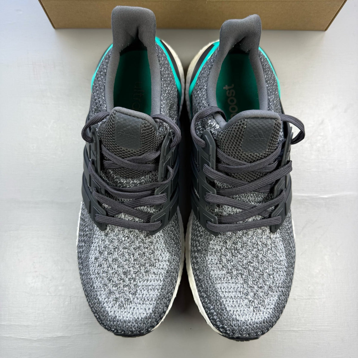 Adidas Ultra Boost 2.0 grey trainers with shock mint accents and logo detailing.