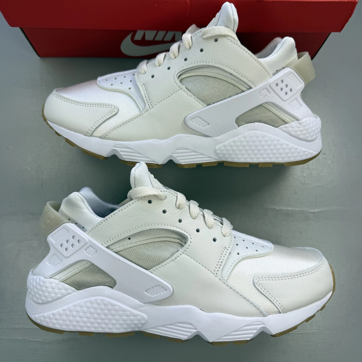 Nike white Air Huarache trainers with gum sole and logo detailing.