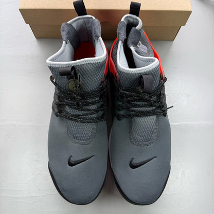 Nike Air Presto grey trainers with black and red accents, featuring a sleek design.