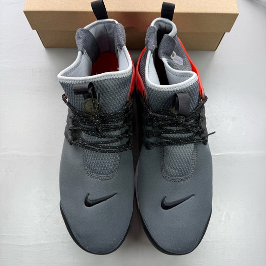 Nike Air Presto grey trainers with black and red accents, featuring a sleek design.