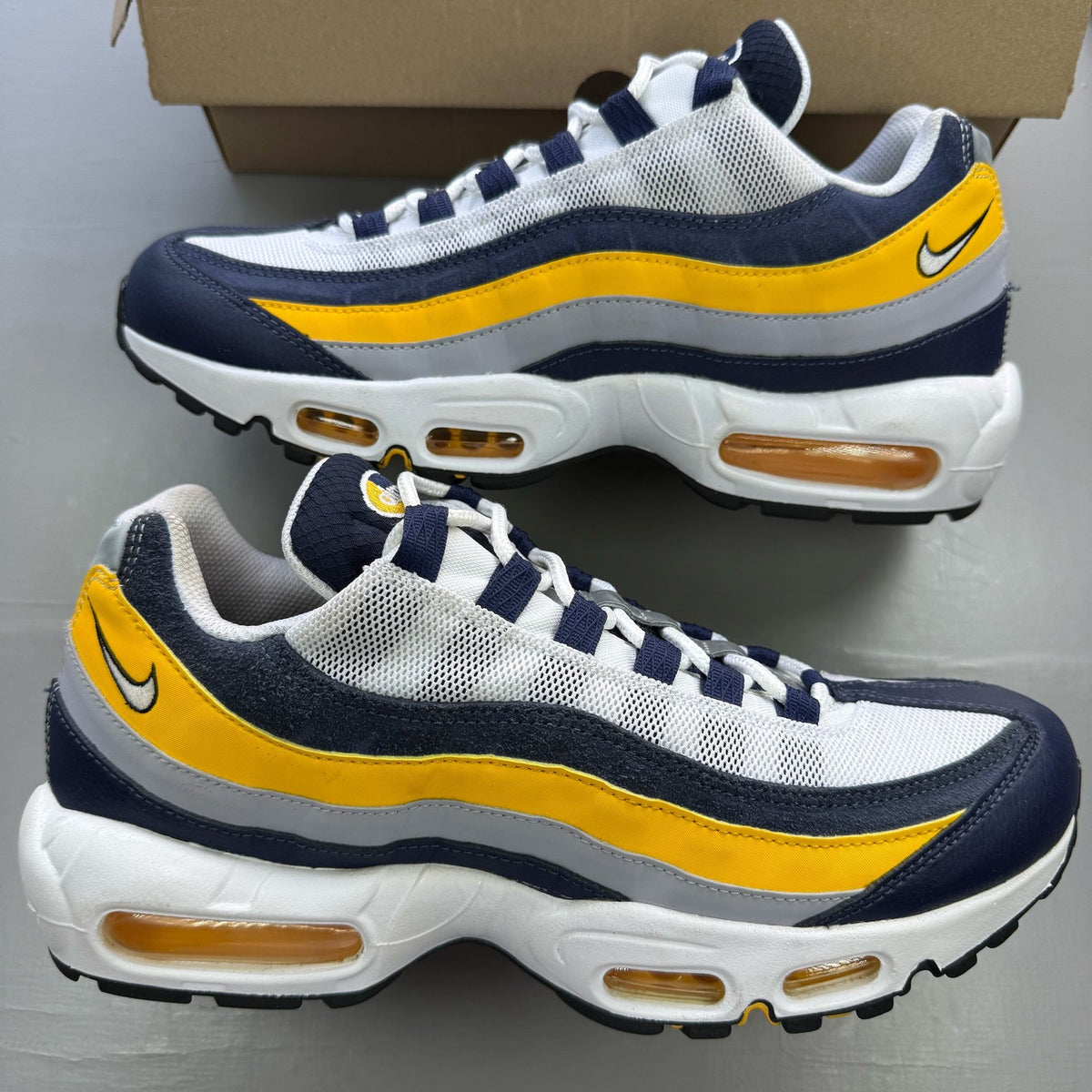 Nike Air Max 95 trainers white with navy and yellow accents, featuring logo on tongue.