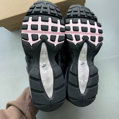 Nike Air Max 95 grey trainers with pink foam accents and black detailing.
