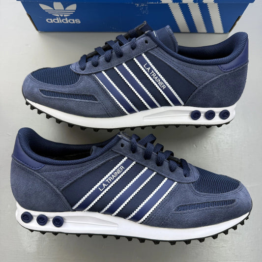 Adidas blue LA Trainer sneakers with white stripes and logo detailing.