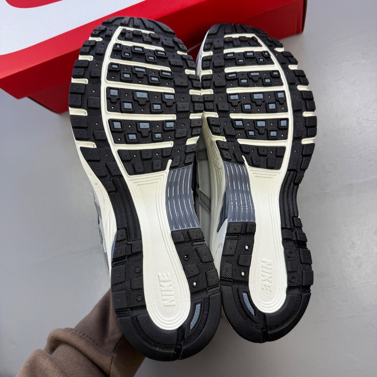 Nike athletic shoes light smoke grey with blue graphite accents and logo details.