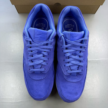 Nike Air Max 1 blue suede trainers with white accents and logo detail.