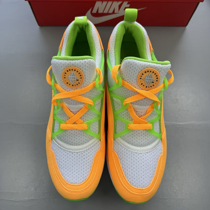 Nike Air Huarache Light white trainers with atomic mango accents and green details.
