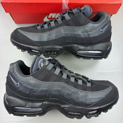 Nike black trainers with grey accents and signature swoosh logo, size UK 9.5.