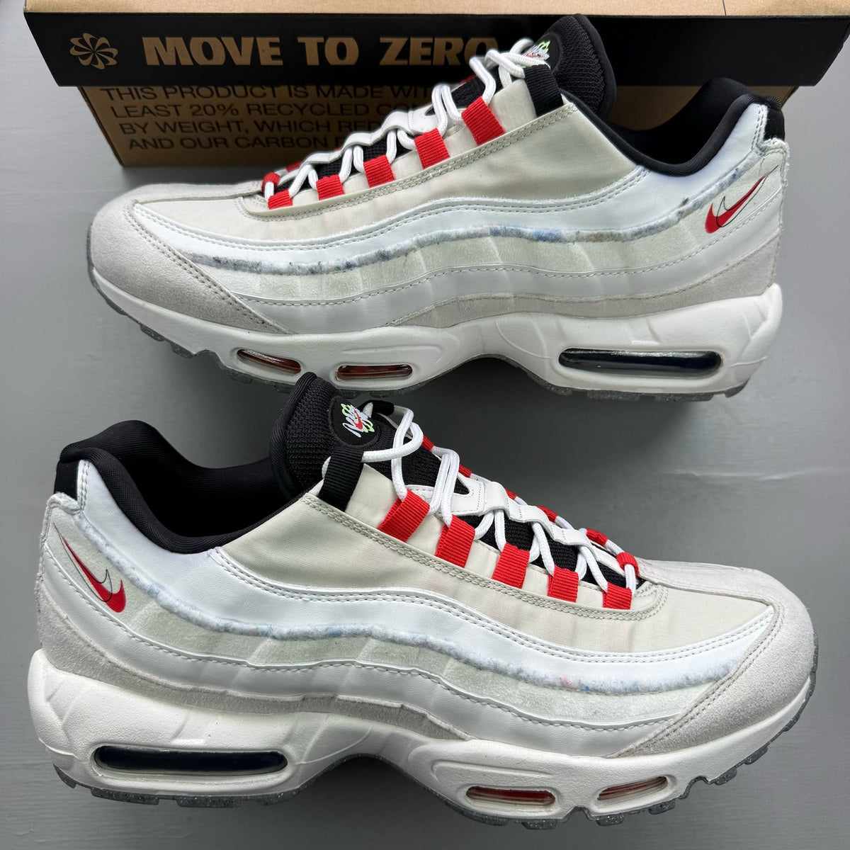 Nike Air Max 95 white trainers with red accents and textured mesh upper.