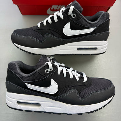 Nike Air Max 1 black trainers with silver and white accents, featuring iconic logo.