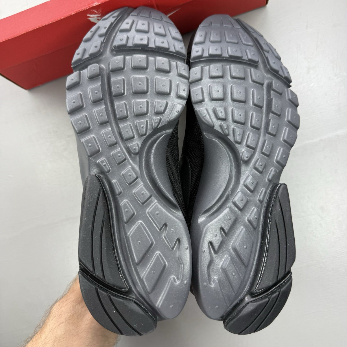Nike Presto Fly black trainers with dark grey accents and logo detail.
