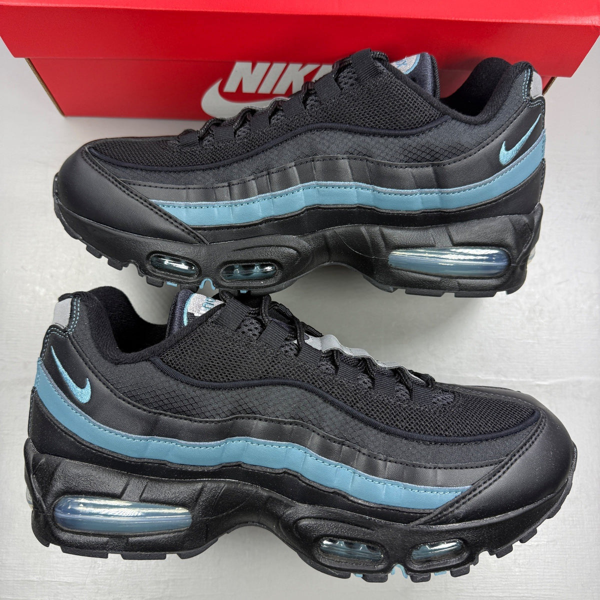 Nike running shoes black with smokey blue accents and visible Air Max cushioning.