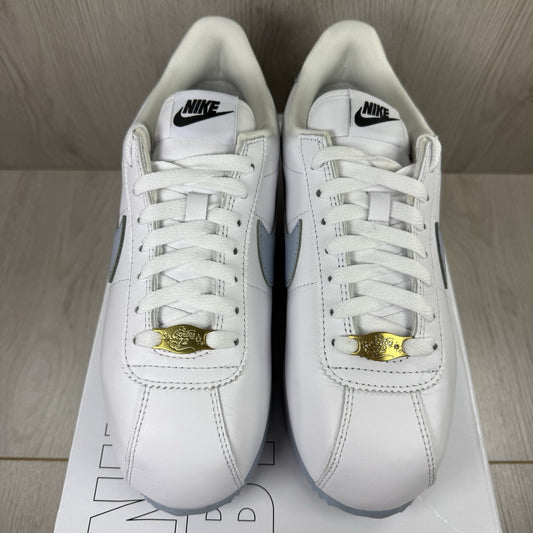 Nike Cortez trainers white with light blue accents and classic swoosh logo.