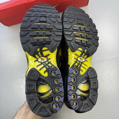 Nike Air Max Plus TN black trainers with bright citron yellow accents and signature logo.