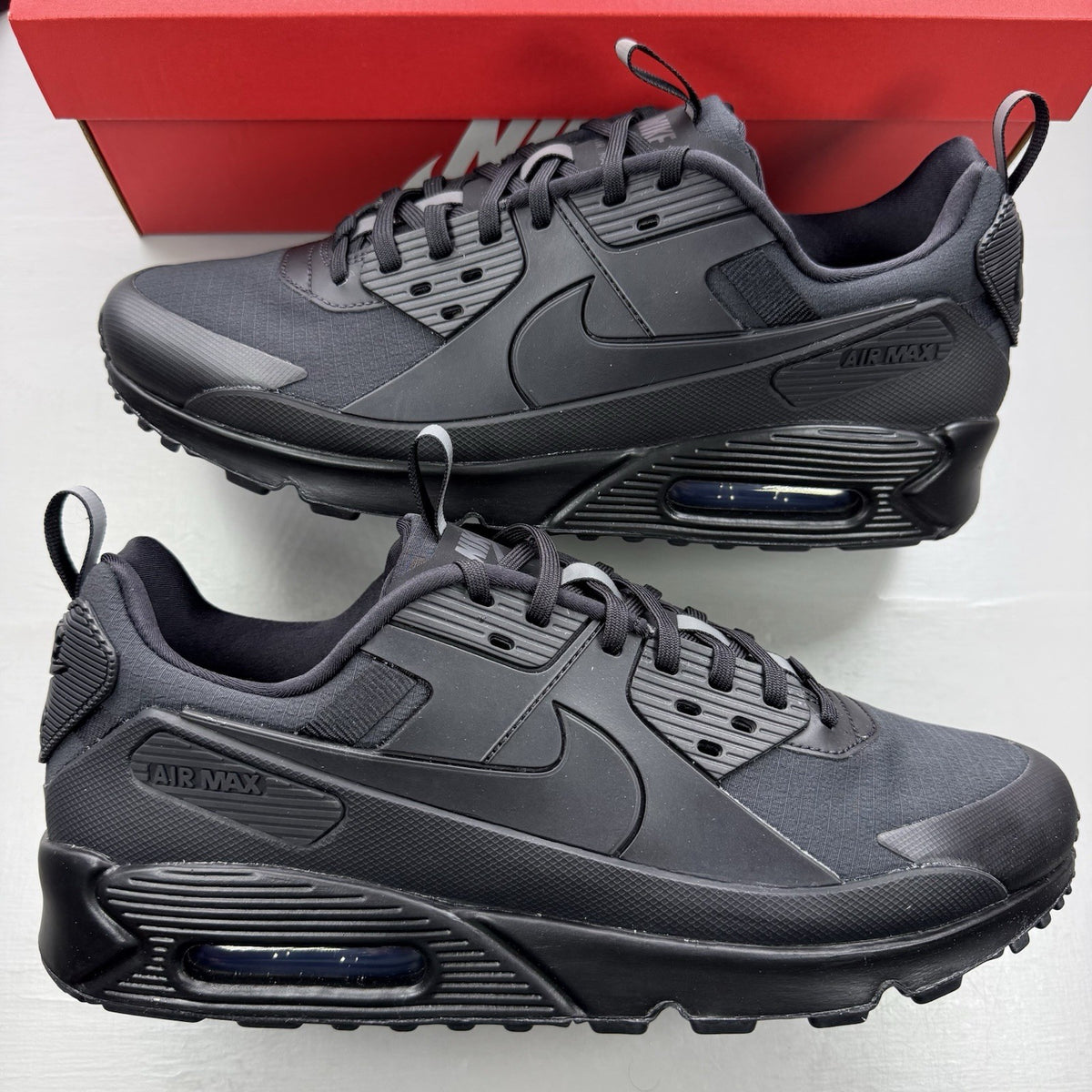 Nike Air Max 90 Drift black trainers with textured upper and signature logo.