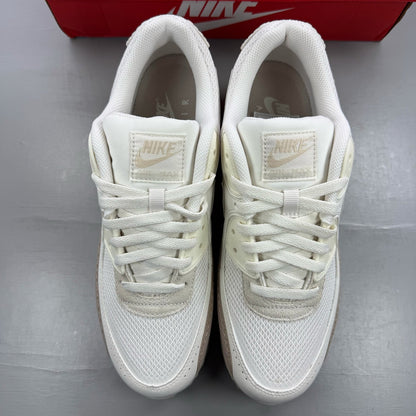 Nike Air Max 90 beige trainers with premium material and iconic logo detail.