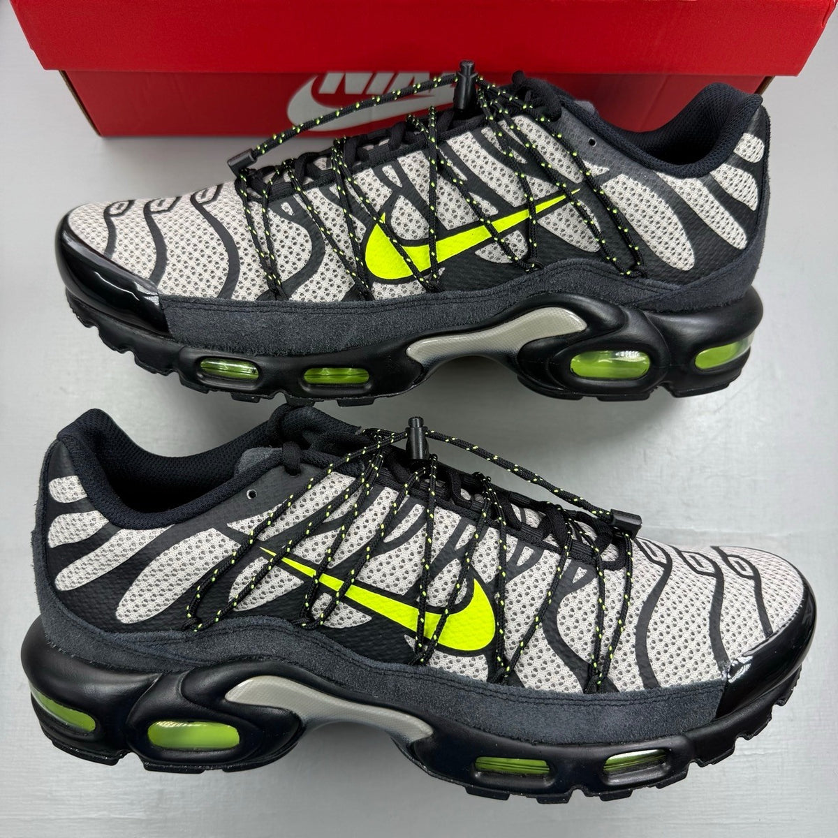 Nike deck shoes black with grey accents and volt detailing, featuring iconic logo.