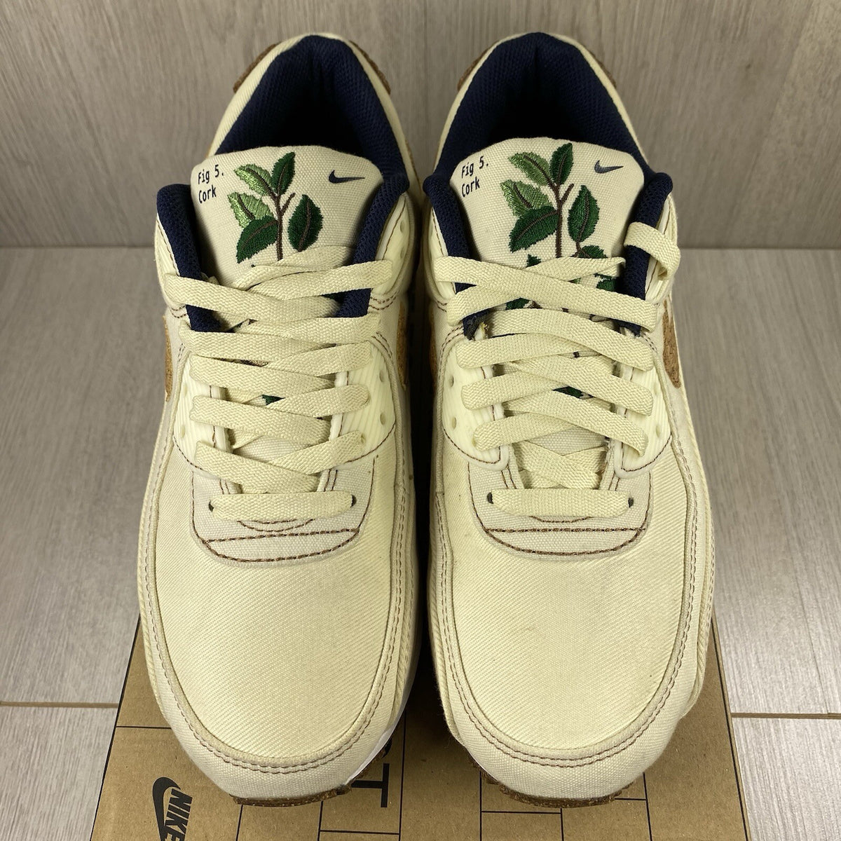 Nike Air Max 90 SE white trainers with cork accents and logo detail.