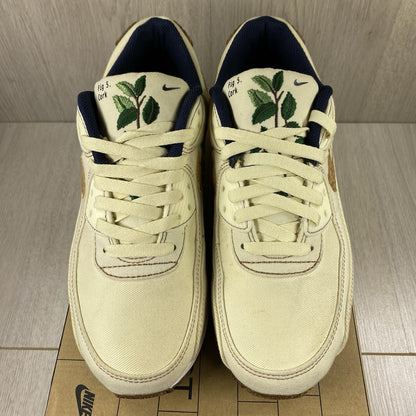 Nike Air Max 90 SE white trainers with cork accents and logo detail.