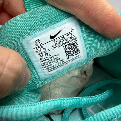 Nike white trainers with bleached turquoise accents and logo detail.