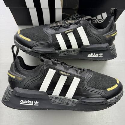 Adidas black trainers with white and gold accents, featuring a sleek design and logo.