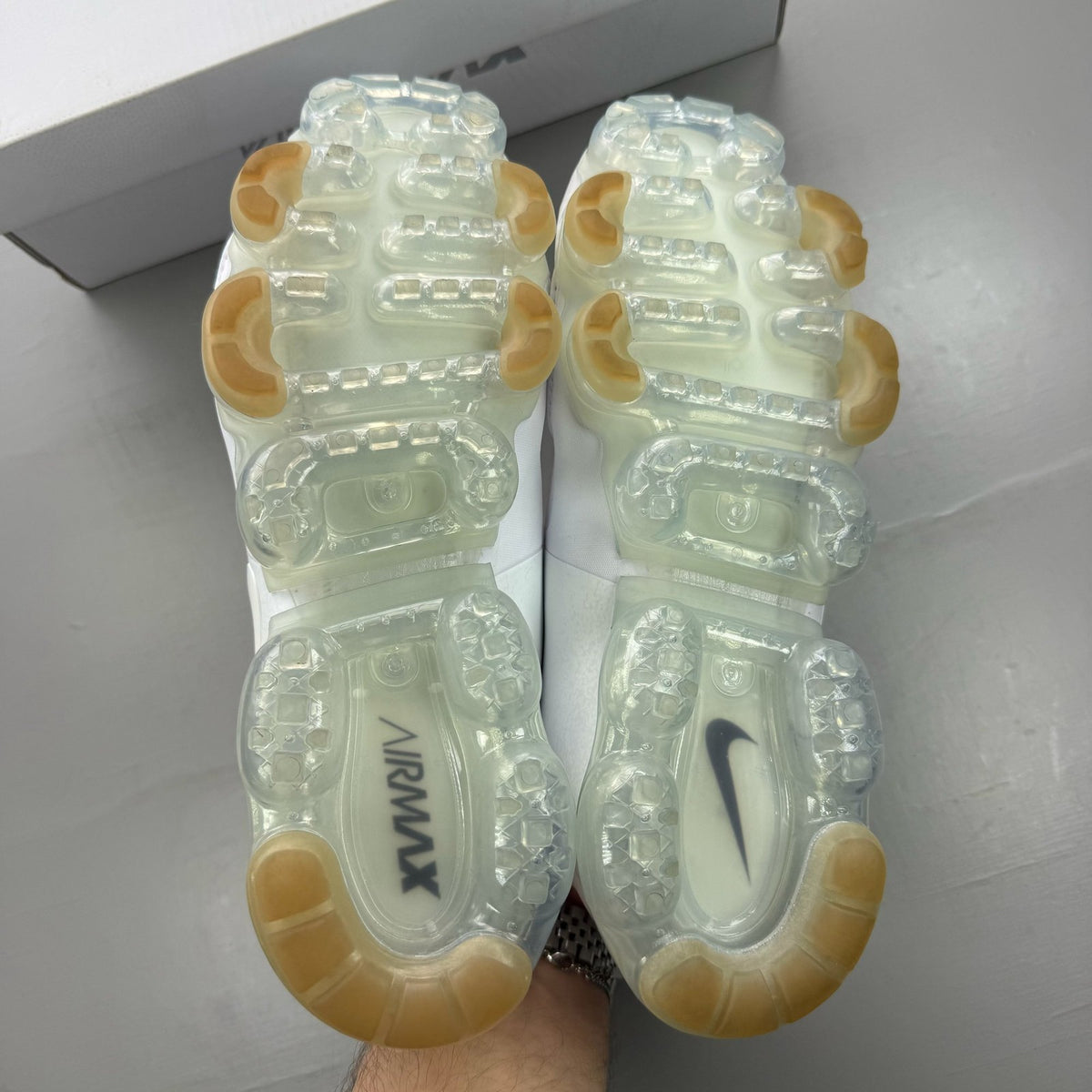 Nike white trainers with gum sole and silver accents, featuring breathable mesh upper.