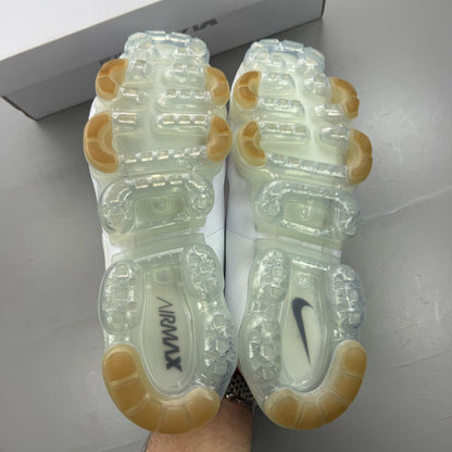 Nike white trainers with gum sole and silver accents, featuring breathable mesh upper.