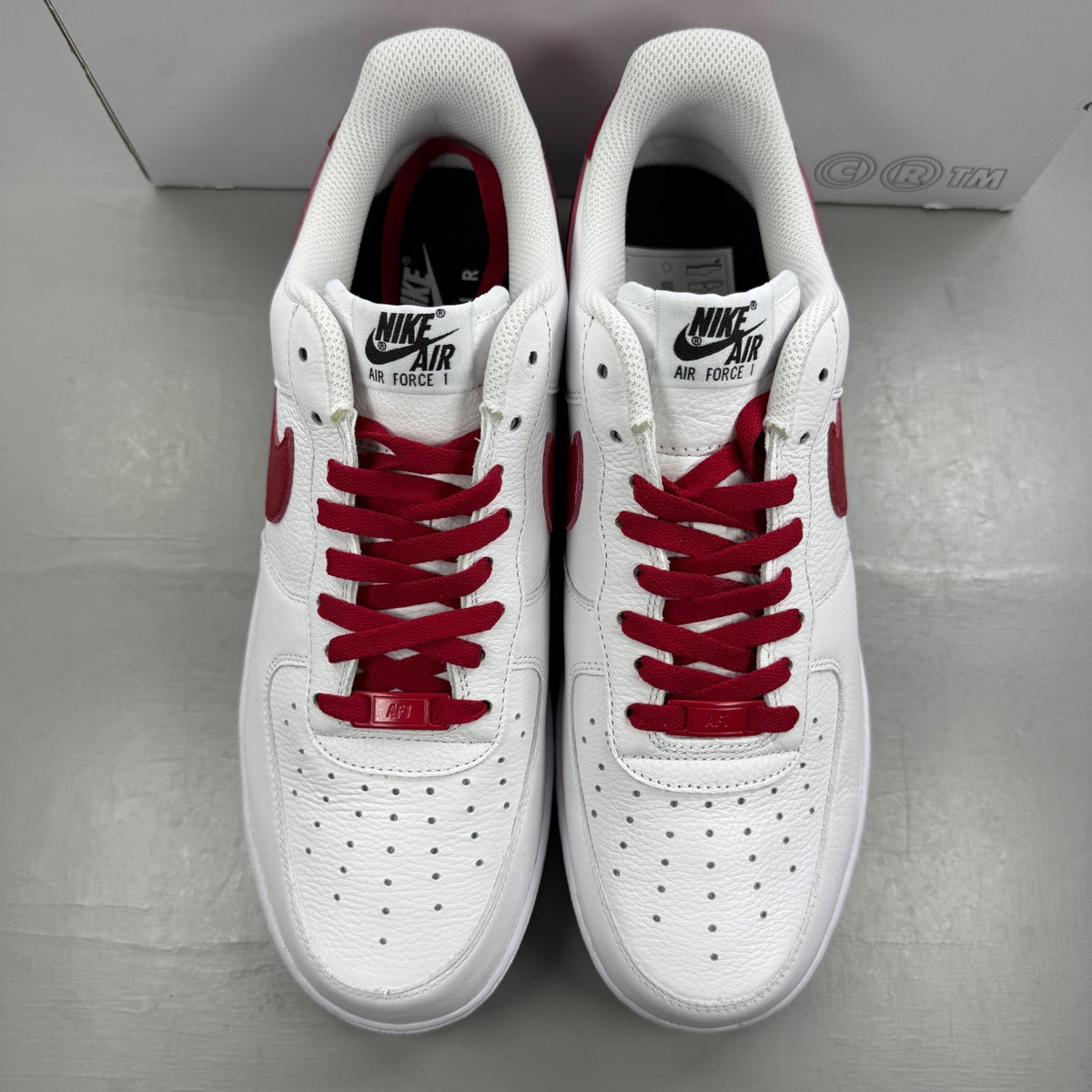 Nike deck shoes white leather with red accents and logo detail.