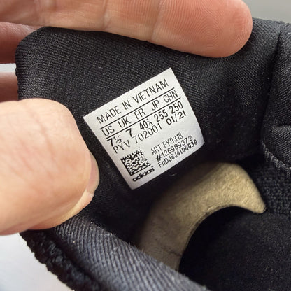 Adidas black Ultra Boost trainers with white accents and signature three-stripe logo.