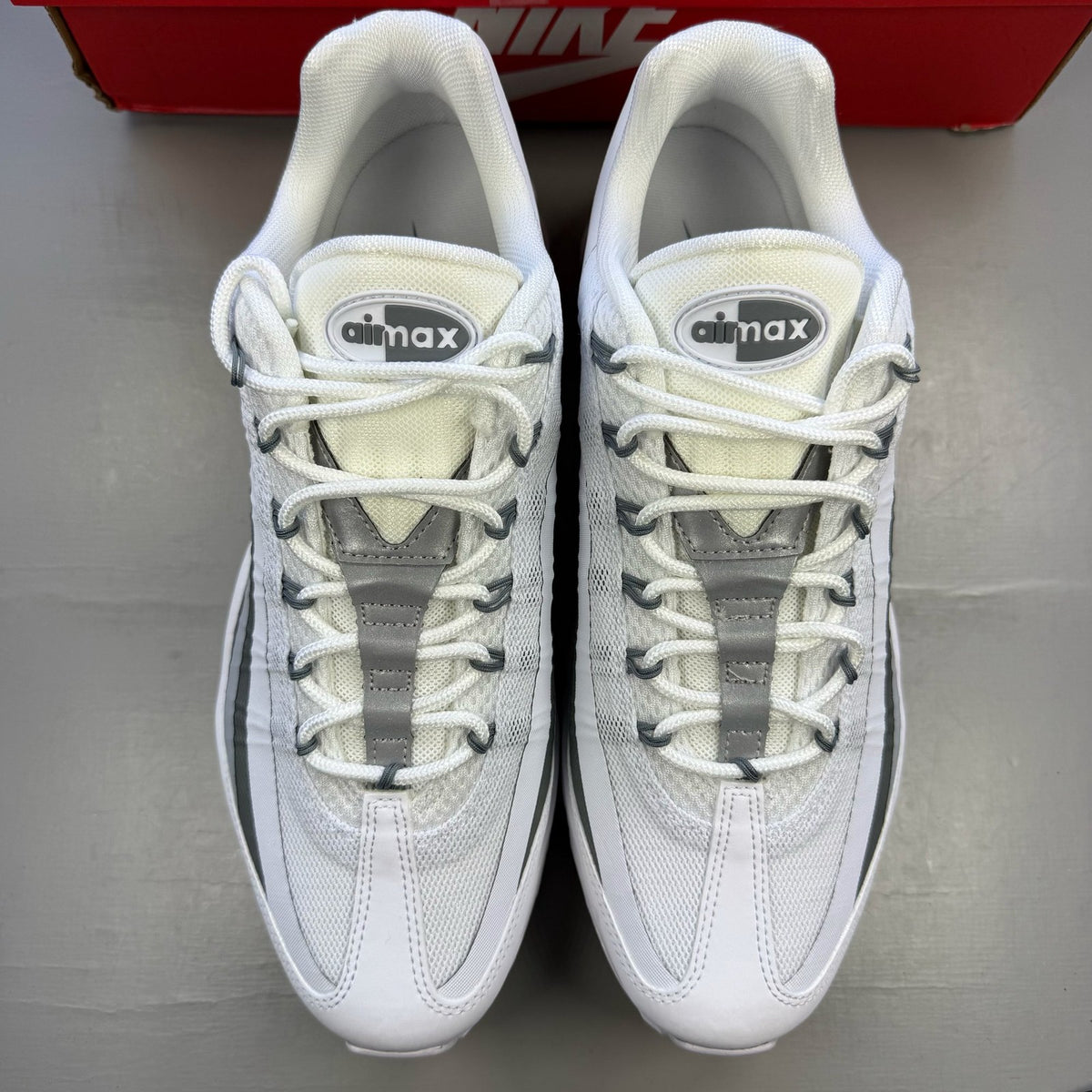 Nike Air Max 95 white trainers with grey accents and signature swoosh logo.