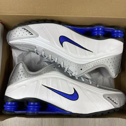 Nike Shox R4 trainers white with blue accents and distinctive Shox cushioning design.