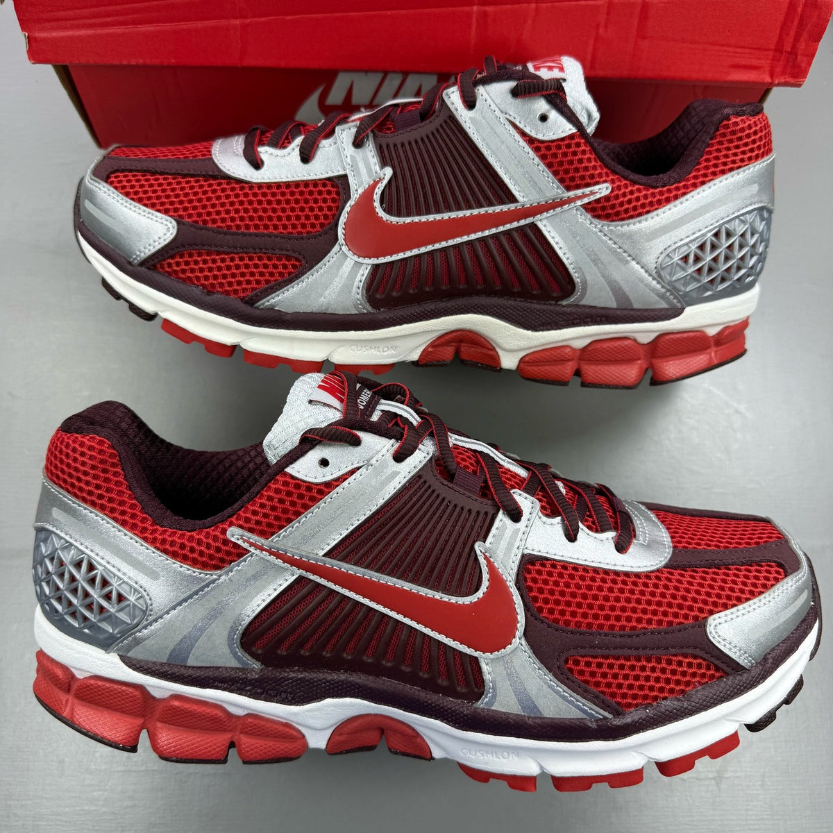 Nike Zoom Vomero 5 black trainers with red accents and white logo details.